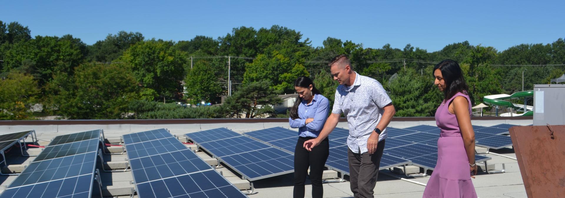 Rep. Sharice Davids with Ryan Evans of SunSmart and Sonia Garapaty of FSC, Inc. discussing recently installed solar panels.