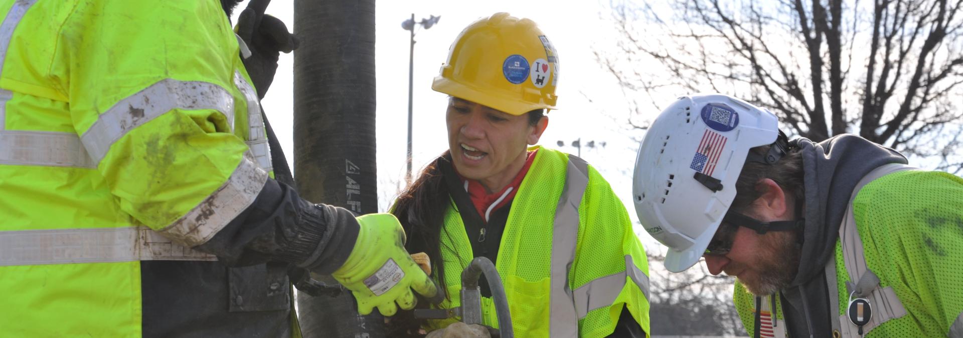 Group of people in high visibility vests and hard hats.
