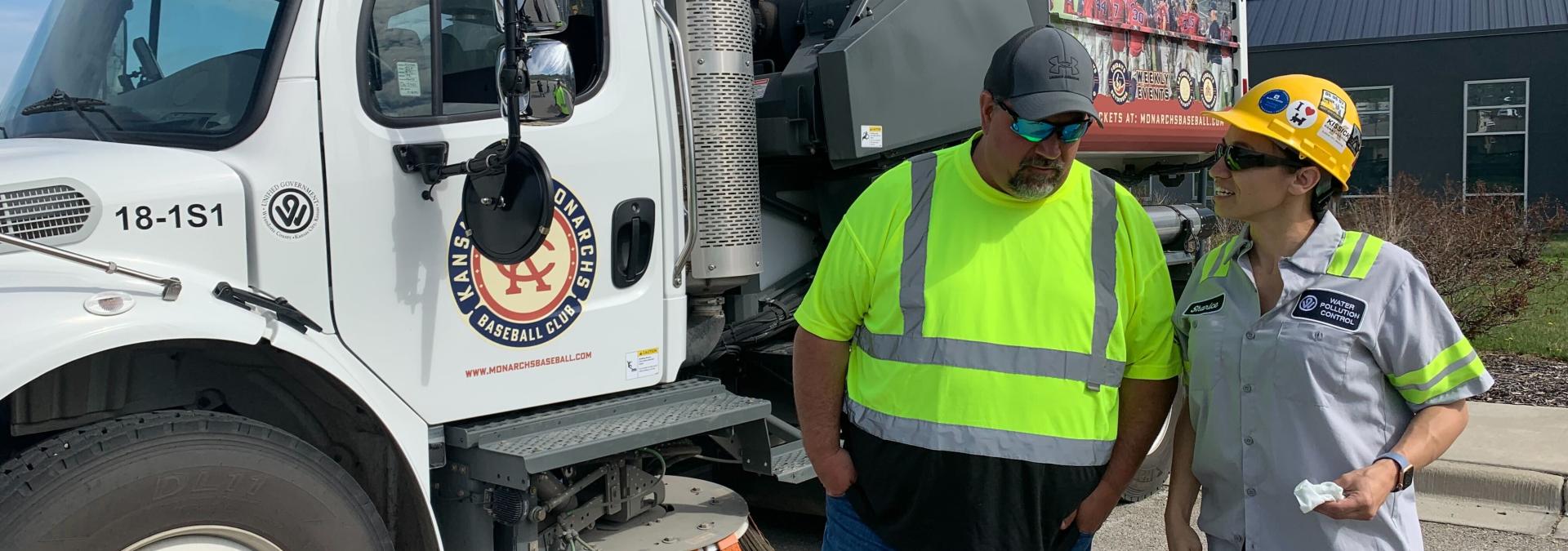 Sharice Davids and a Wyandotte County maintenance staff member stand next to a street sweeper