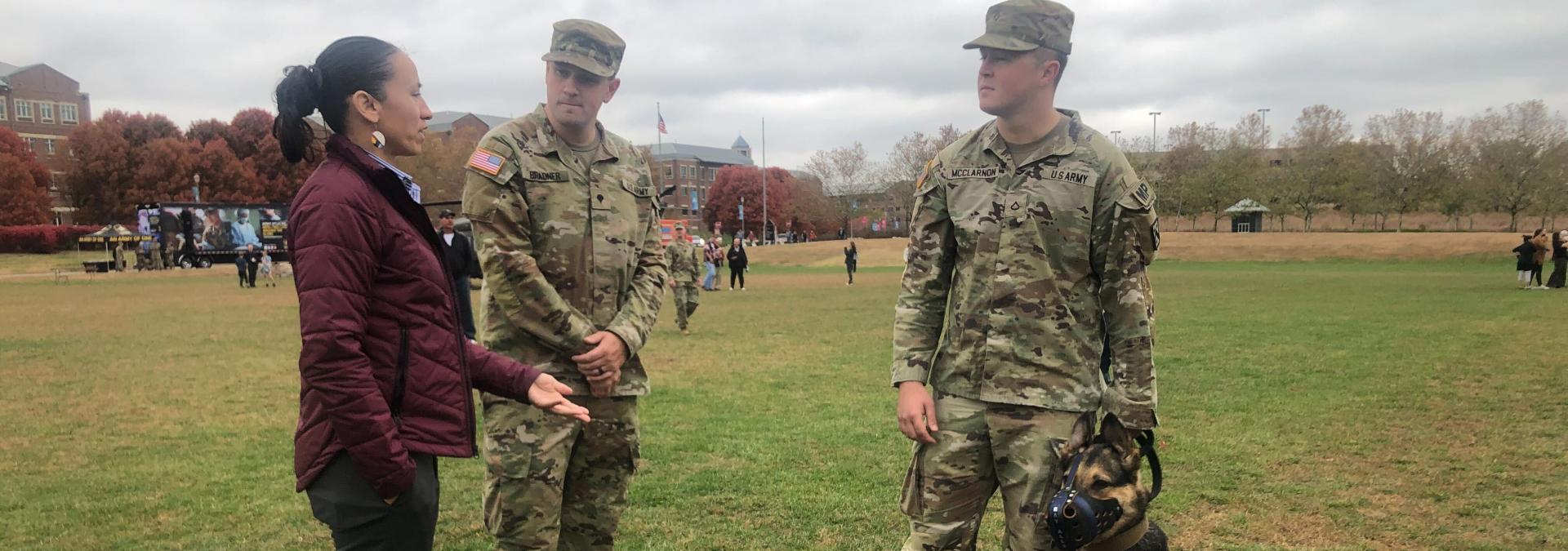 Sharice Davids with two people in army fatigues and a service dog