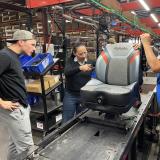 Rep. Sharice Davids helping to manufacture seats for heavy trucks.