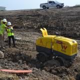 Rep. Sharice Davids operating the remote control trench compactor to prepare for construction on the US 69 expansion project.