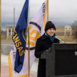 Sharice Davids standing at podium with flags behind her
