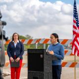 Rep Davids at a podium outdoors in front of an American flag