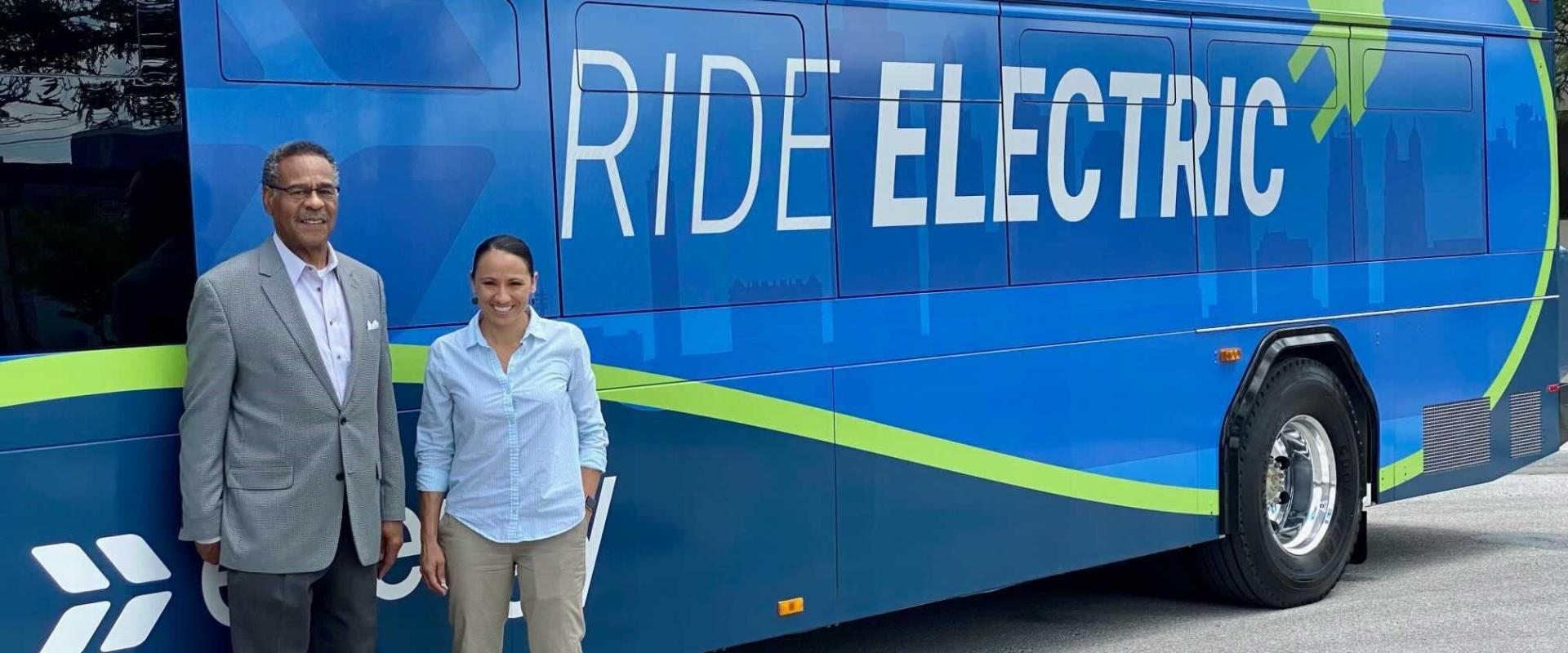Rep. Davids and Rep. Cleaver stand in front of an electric city bus