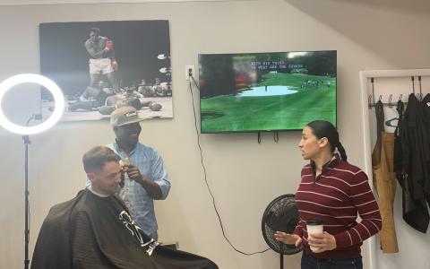 Rep. Sharice Davids chatting with JC Barbershop management and a local customer, Brad.