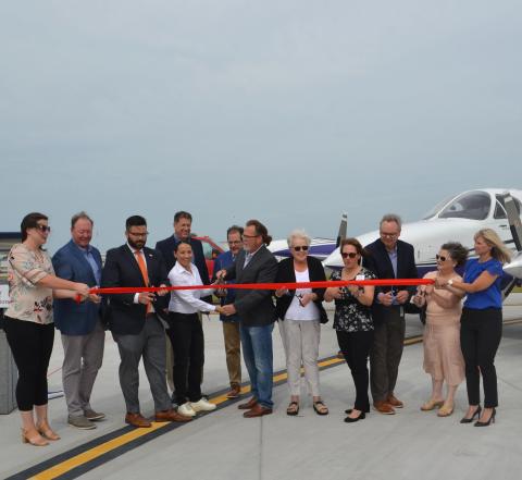 Rep. Sharice Davids, John County leadership, and Johnson County Executive Airport staff cutting a ribbon to open Taxiway Bravo.