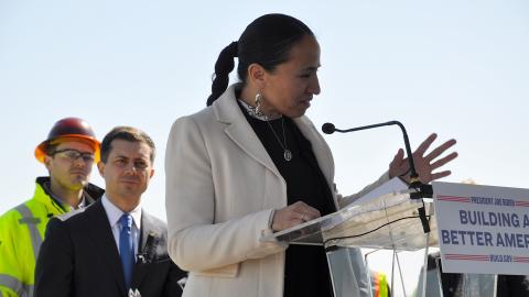 Rep. Sharice Davids stands in front of the U.S. Secretary of Transportation in Desoto, Kansas