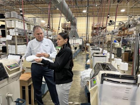 Two people standing in manufacturing warehouse