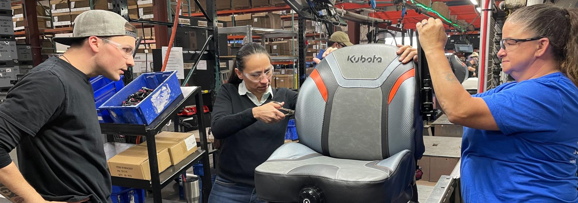 Rep. Sharice Davids helping to manufacture seats for heavy trucks.