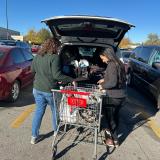 Representative Davids loading groceries into a constituent's car. 