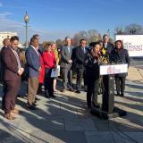 Rep Davids at a podium outdoors in front of a group of people