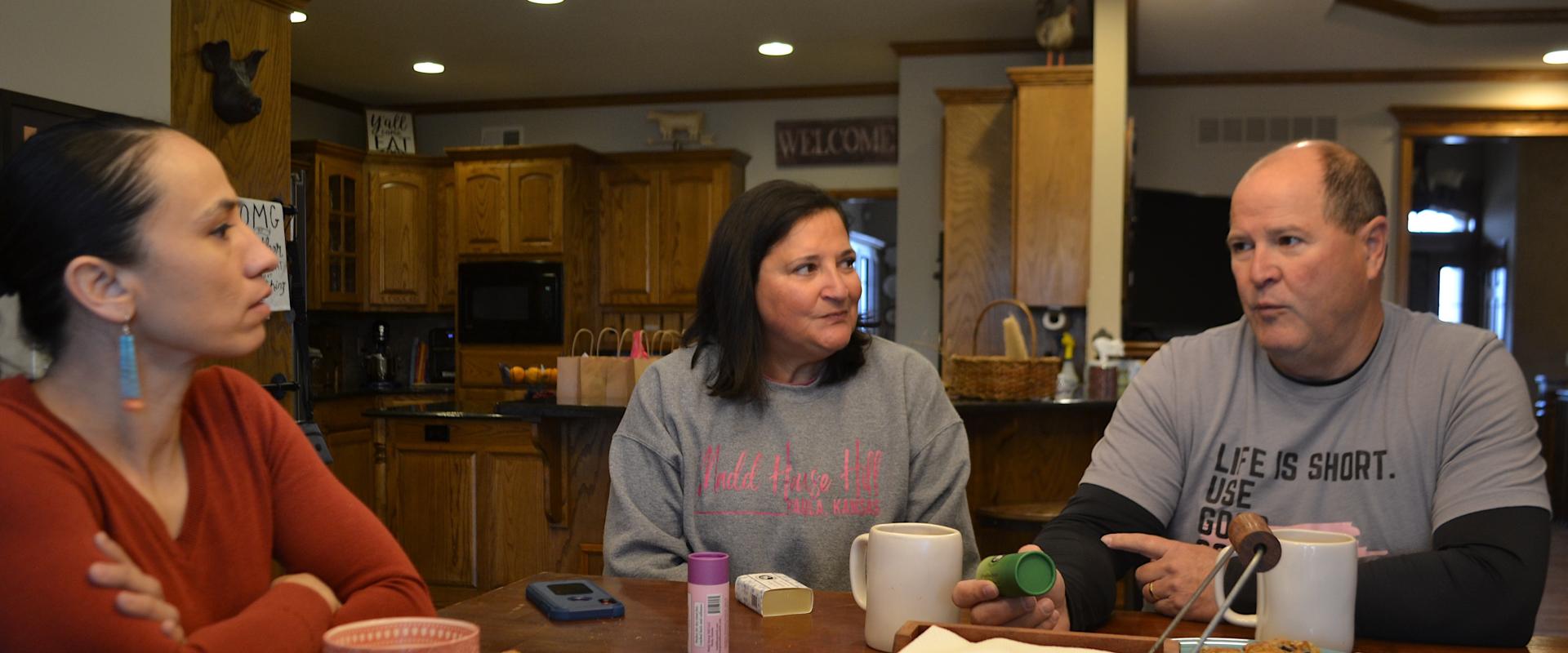 Rep. Sharice Davids sitting with constituents at a kitchen table