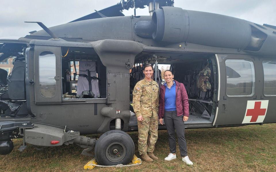 Rep. Davids with a servicemember in uniform in front of a helicopter